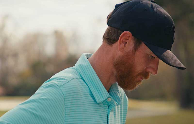 golfer with beard looking down